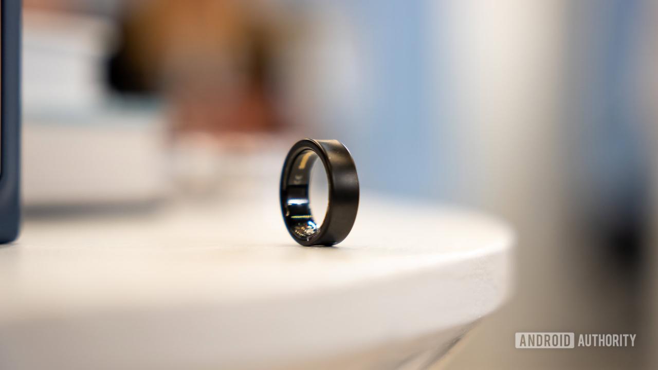 一枚黑色钛合金的三星 Galaxy Ring 放置在白色表面上