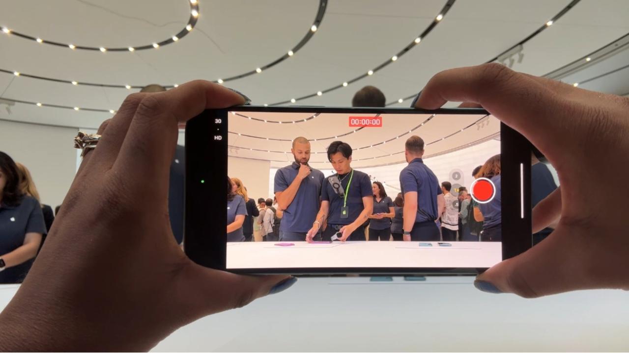 一位女士在 Apple 活动上用 iPhone 录制媒体嘉宾