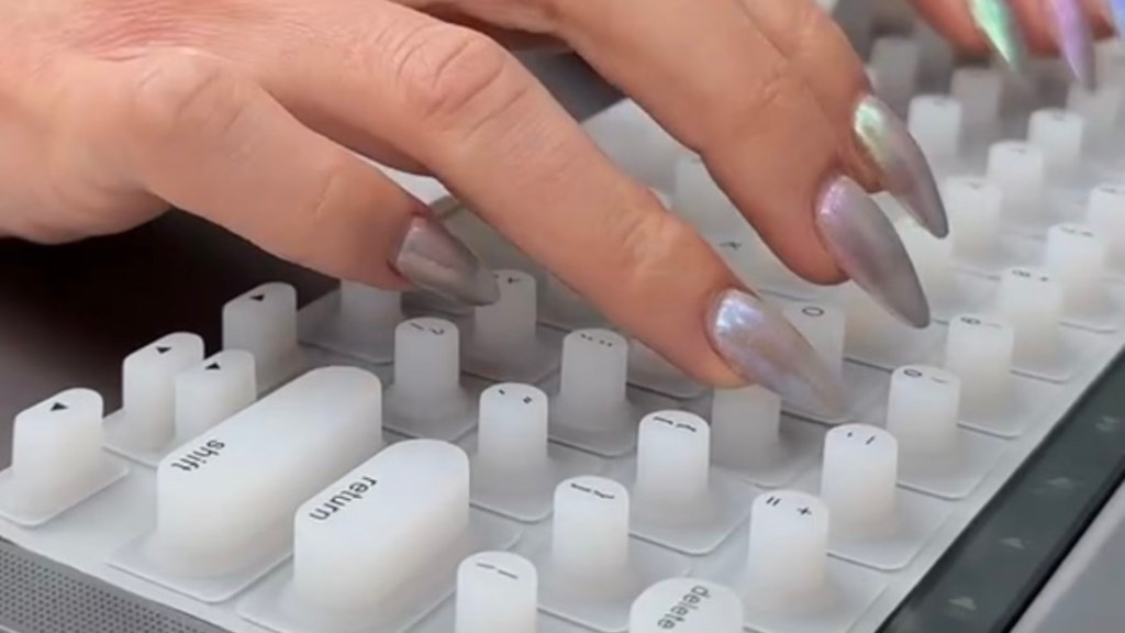 使用 Gen Z 设计的长指甲键盘的手