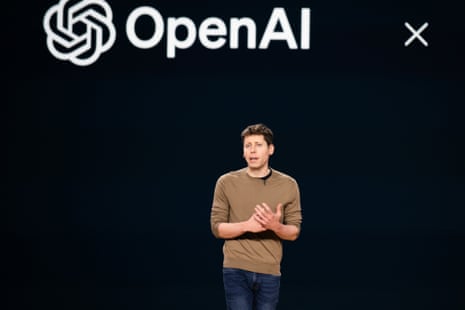 图片 34：一名男子站在黑色屏幕前，屏幕上用白色字母写着“OpenAI”