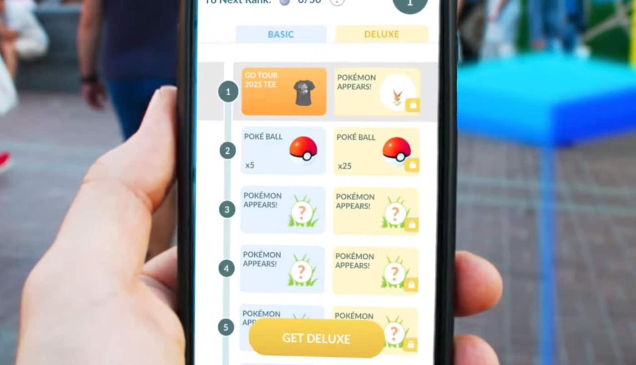 一只手拿着手机，展示了在 Pokémon GO Tour Unova 首次亮相的 Tour Pass 和 Tour Pass Deluxe 之间的差异