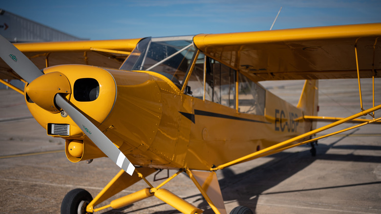 一架黄色的 Piper PA-18 轻型高翼飞机在跑道上