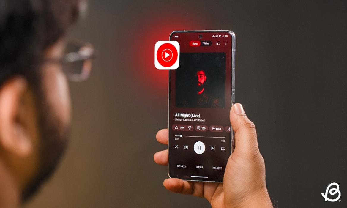手持手机，打开 YouTube Music 应用的人