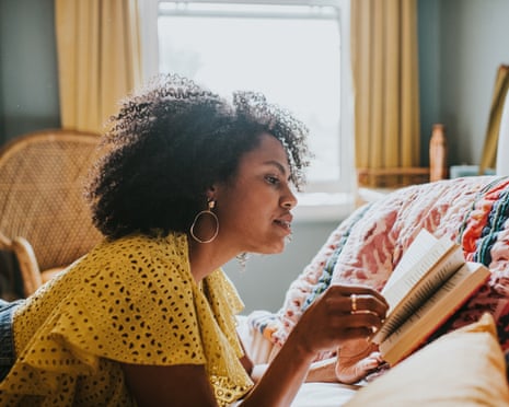 一位女性躺在床上看书